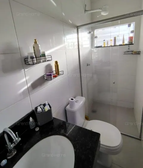 Banheiro com box de vidro e pia de granito
