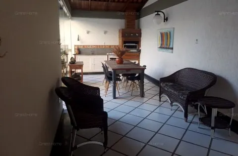 Área gourmet coberta com churrasqueira e mesa