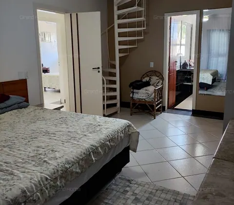 Quarto com escada em caracol e porta para o banheiro