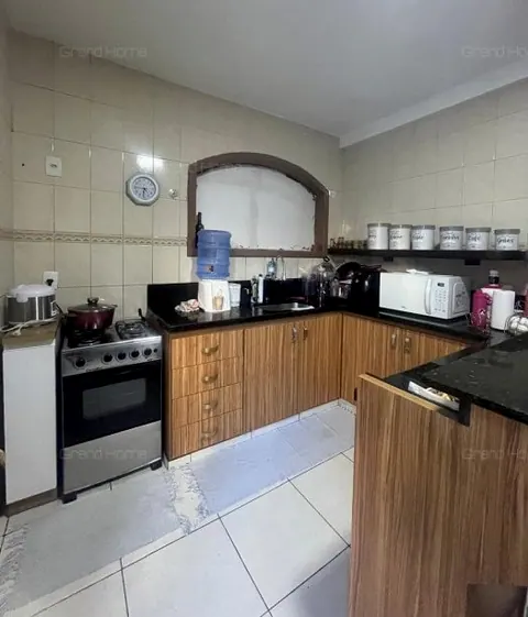 Cozinha com armários de madeira e bancada de pedra escura