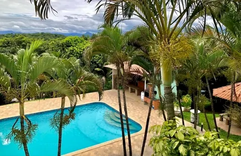Vista do alto da piscina e da área verde do sítio