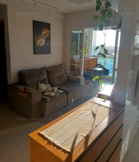 Sala com sofá cinza e porta de vidro para a varanda
