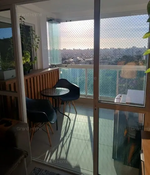 Varanda envidraçada com mesa redonda e cadeiras pretas