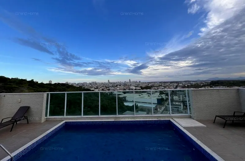 Piscina do condomínio com deck e vista aberta para a cidade