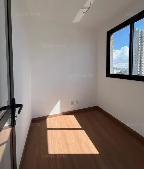 Quarto vazio com janela ampla e piso amadeirado