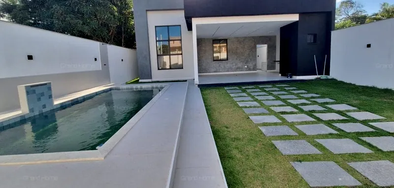 Fachada da casa com a piscina e o jardim