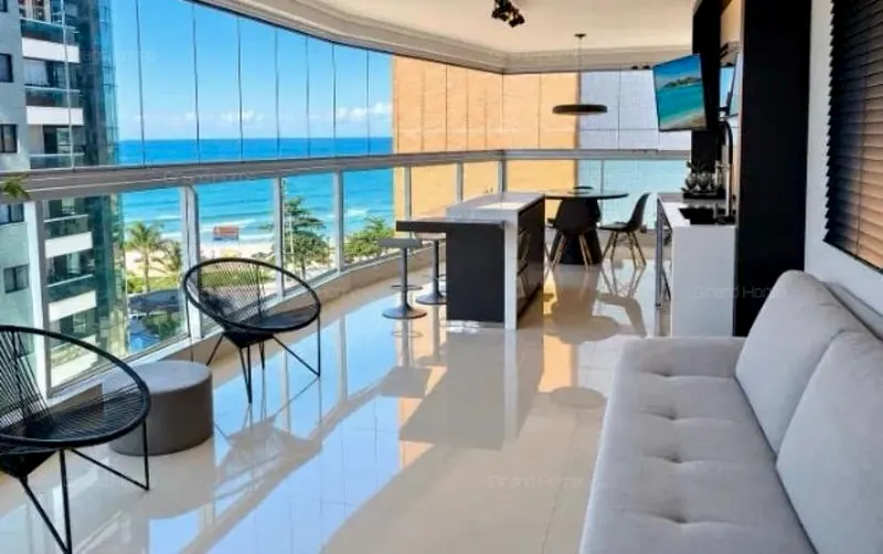 Sala com a varanda envidraçada e a vista para o mar