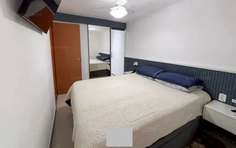 Quarto de casal com cabeceira azul e armário com espelho